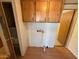 An interior shot of the laundry room with wooden cabinets and linoleum floors at 8103 E Southern Ave # 157, Mesa, AZ 85209
