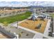 Aerial view of a neighborhood playground with slides, swings, and green space for community enjoyment at 8149 E Petunia Ave # 1057, Mesa, AZ 85212