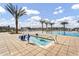 View of a luxurious community swimming pool with palm trees, lounge chairs and splash pad at 8149 E Petunia Ave # 1043, Mesa, AZ 85212