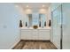 Bright bathroom featuring double sinks, modern fixtures, and a glass-enclosed shower at 8331 E Petunia Ave, Mesa, AZ 85212