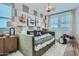 A cozy bedroom featuring a green daybed, neutral walls, and drum art at 8331 E Petunia Ave, Mesa, AZ 85212