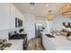 Modern kitchen with white cabinetry, stainless steel appliances, a central island, and wood-look flooring at 8331 E Petunia Ave, Mesa, AZ 85212