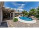 A patio overlooks a pool, surrounded by rocks and lush landscaping in the backyard at 8441 W Foothill Dr, Peoria, AZ 85383