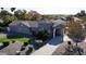 Stunning stone home featuring a circular entry, porte-cochere, and meticulously landscaped front yard with lush greenery at 8441 W Foothill Dr, Peoria, AZ 85383