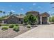 Handsome stone home with circular tower, porte-cochere, and landscaped front yard with mature trees and shrubs at 8441 W Foothill Dr, Peoria, AZ 85383