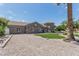 Stately stone home with a modern architectural design, including a circular tower, and a well-maintained front yard at 8441 W Foothill Dr, Peoria, AZ 85383