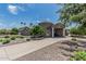 Charming stone home with lush landscaping, porte-cochere, and well-maintained front yard with mature trees and shrubs at 8441 W Foothill Dr, Peoria, AZ 85383