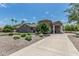 Handsome stone home with a circular architectural feature, porte-cochere, and professionally landscaped front yard at 8441 W Foothill Dr, Peoria, AZ 85383