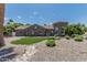 Charming stone home with a well-manicured yard featuring decorative rock and a patch of green grass at 8441 W Foothill Dr, Peoria, AZ 85383