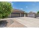 Three-car garage featuring decorative doors, spacious driveway, and manicured landscaping, with potential RV gate at 8441 W Foothill Dr, Peoria, AZ 85383