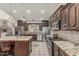 A full kitchen view featuring stainless steel appliances, tile backsplash, and granite countertops at 8441 W Foothill Dr, Peoria, AZ 85383