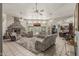 Open-concept living room featuring a stone fireplace, multiple ceiling fans, and access to the backyard at 8441 W Foothill Dr, Peoria, AZ 85383