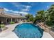 A view of the pool with waterfall, surrounded by palm trees and lush vegetation at 8441 W Foothill Dr, Peoria, AZ 85383