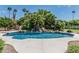 Backyard oasis with a sparkling pool, rock waterfall, and mature landscaping, perfect for relaxing at 8441 W Foothill Dr, Peoria, AZ 85383