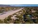 Aerial view of desert homes bordering a runway, set against a backdrop of mountains and desert landscape at 8502 E Cave Creek Rd # 61, Carefree, AZ 85377