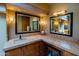This bathroom is equipped with dual sinks, travertine countertops, and decorative framed mirrors at 8502 E Cave Creek Rd # 61, Carefree, AZ 85377