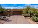Exterior view of a brown stucco home with a large garage and desert landscaping along a paved driveway at 8502 E Cave Creek Rd # 61, Carefree, AZ 85377