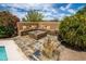 Relaxing outdoor area with a built-in fire pit and seating, surrounded by lush desert landscaping and open skies at 8502 E Cave Creek Rd # 61, Carefree, AZ 85377