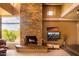 Inviting living room with a stone fireplace, TV, and plush seating with a view at 8502 E Cave Creek Rd # 61, Carefree, AZ 85377