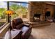 Cozy living room featuring a stone fireplace and comfortable leather chair with a view at 8502 E Cave Creek Rd # 61, Carefree, AZ 85377