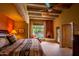 This main bedroom features wooden beam ceilings, a fireplace and picturesque backyard views with pool access at 8502 E Cave Creek Rd # 61, Carefree, AZ 85377