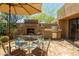 Inviting outdoor patio with built-in grill, fireplace, and shaded seating area at 8502 E Cave Creek Rd # 61, Carefree, AZ 85377
