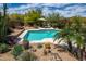An aerial view of a pool area with lounge chairs, lush landscaping, and desert plants at 8502 E Cave Creek Rd # 61, Carefree, AZ 85377