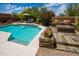 Inviting backyard pool with baja step, waterfall feature, and outdoor seating around a stacked stone fire pit at 8502 E Cave Creek Rd # 61, Carefree, AZ 85377