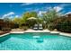 A beautiful pool with a tanning ledge, waterfall, and lounge chairs surrounded by manicured desert landscaping at 8502 E Cave Creek Rd # 61, Carefree, AZ 85377