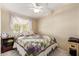 Cozy bedroom with a window, ceiling fan, and a decorative quilt on the bed at 931 S 91St Pl, Mesa, AZ 85208