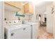 A spacious laundry area features wood cabinets and modern, white appliances, complemented by a decorative 'Laundry' sign at 931 S 91St Pl, Mesa, AZ 85208