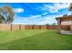 Expansive backyard featuring a lush green lawn, privacy wall, and covered patio, perfect for outdoor living and entertaining at 11501 N Pablo St, El Mirage, AZ 85335