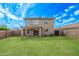 Spacious backyard with a well-maintained lawn, covered patio, and access to the home's sliding glass doors, for seamless indoor/outdoor living at 11501 N Pablo St, El Mirage, AZ 85335