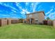 Large backyard showcasing a lush lawn, covered patio, and secure privacy wall, ideal for relaxation and Gathering activities at 11501 N Pablo St, El Mirage, AZ 85335