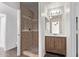 Bathroom featuring wood vanity, modern sink, and a walk-in tile shower at 11501 N Pablo St, El Mirage, AZ 85335