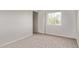 Cozy bedroom with neutral carpet, bright window, and a closet for ample storage at 11501 N Pablo St, El Mirage, AZ 85335