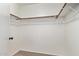 Empty walk in closet has carpet and wood racks with white hardware at 11501 N Pablo St, El Mirage, AZ 85335