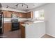 A kitchen features dark wood cabinets, stainless appliances and a breakfast bar at 11501 N Pablo St, El Mirage, AZ 85335