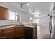 Kitchen sink with oak cabinets overlooks a bright and large living area at 11501 N Pablo St, El Mirage, AZ 85335