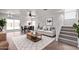 A light and airy living room with a staircase, dining set, and a comfortable sofa on a stylish rug at 11501 N Pablo St, El Mirage, AZ 85335