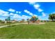 Community playground with colorful equipment set on a well-maintained lawn under a bright sky at 11501 N Pablo St, El Mirage, AZ 85335