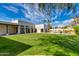 Expansive backyard featuring a lush lawn, swimming pool, and desert landscaping under a bright blue sky at 13238 N 78Th St, Scottsdale, AZ 85260