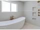 Luxurious bathroom featuring a freestanding tub, gold fixtures, and tiled shower niche at 13238 N 78Th St, Scottsdale, AZ 85260