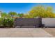 Gated driveway featuring stamped concrete, desert landscaping, and mature trees at 13238 N 78Th St, Scottsdale, AZ 85260