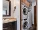 A cozy laundry area with a stacked washer and dryer unit with storage shelf above the appliances at 13238 N 78Th St, Scottsdale, AZ 85260