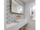 Stylish powder room featuring decorative tiles, modern sink, and brass fixtures at 13238 N 78Th St, Scottsdale, AZ 85260