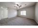 Cozy bedroom featuring a ceiling fan and neutral-toned carpet, bathed in natural light at 14262 N 142Nd Ln, Surprise, AZ 85379