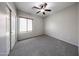 This carpeted bedroom has a ceiling fan, window with blinds, and a built-in closet at 14262 N 142Nd Ln, Surprise, AZ 85379