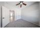 Bright bedroom with neutral walls, carpet flooring, a ceiling fan, closet, and en suite bathroom at 14262 N 142Nd Ln, Surprise, AZ 85379