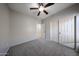 This carpeted bedroom has gray walls, closet, access to an adjacent bathroom, and a ceiling fan at 14262 N 142Nd Ln, Surprise, AZ 85379